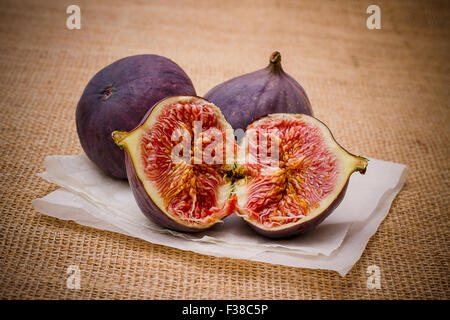 Three ripe figs on baking paper background, close up Stock Photo