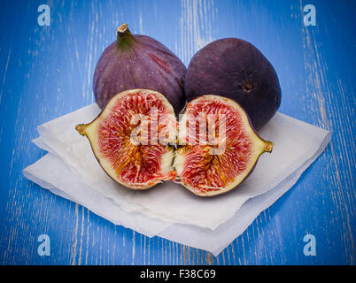 Three ripe figs on baking paper background, close up Stock Photo