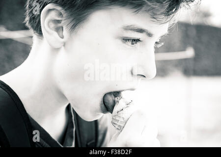black and white shot of a teenage boy eating an ice cream Stock Photo