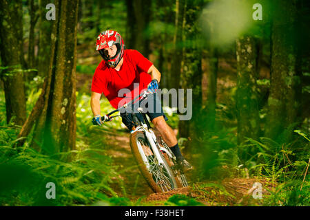 Mountain Biker Riding Down Beautiful Lush Forest Trail in the Mountains Stock Photo