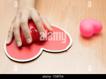 Female hand with computer mouse on table.valentine day Stock Photo