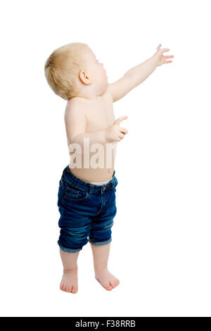 A little boy at the shows to something. White background. Studio Stock Photo