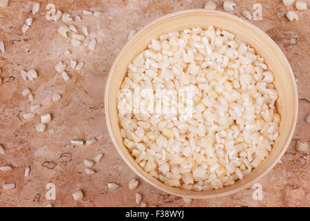 White grated corn kernels in wooden bowl on marble table. Selective focus. Toning effect Stock Photo