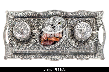 Table setting with silver tableware and dates. Oriental hospitality concept with tea or coffee cups. Top view Stock Photo