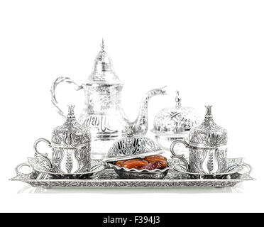 Table setting with silver tableware and dates. Oriental hospitality concept with tea or coffee cups. High key picture Stock Photo