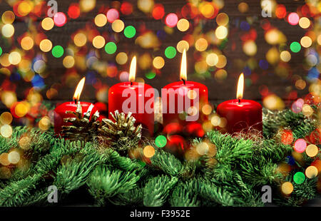Advent decoration with four red burning candles and colorful lights. Holidays background. Stock Photo