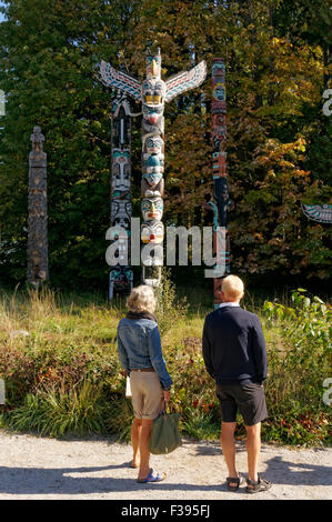 Older woman and man looking at totem poles at Brockton Point in Stanley Park, Vancouver, British Columbia, Canada Stock Photo