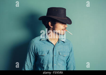 A young cowboy is smoking a cigarette Stock Photo