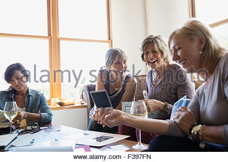 Women drinking wine and looking at photographs