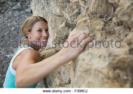 Close up smiling woman rock climbing