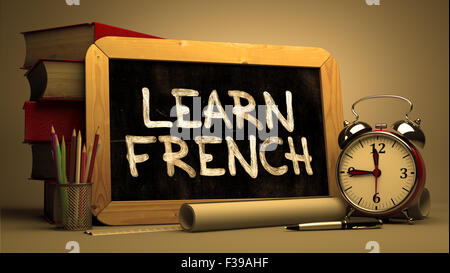 Learn French - Motivational Quote Handwritten on Chalkboard. Time Concept. Composition with Chalkboard and Stack of Books, Alarm Stock Photo