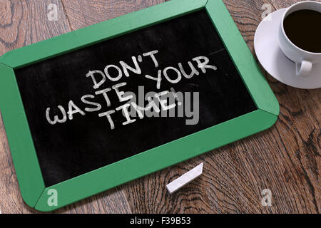 Don't Waste Your Time - Motivational Quote Hand Drawn on Green Chalkboard on Wooden Table. Business Background. Top View. Stock Photo