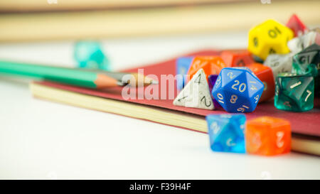Close up of multicolored dice with Pencils on a red Notebook Stock Photo