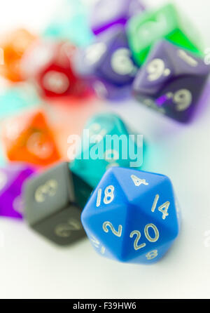 Tilted macro shot of blue twenty sided dice with other dice out of focus on a white background Stock Photo