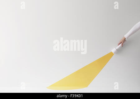 Conceptual hand holding a torch with light beam Stock Photo