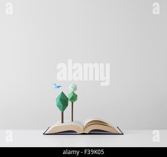 Trees and bird growing out of an open pop-up book Stock Photo