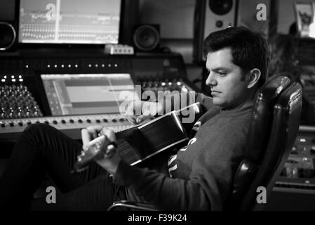 Man playing guitar in recording studio Stock Photo