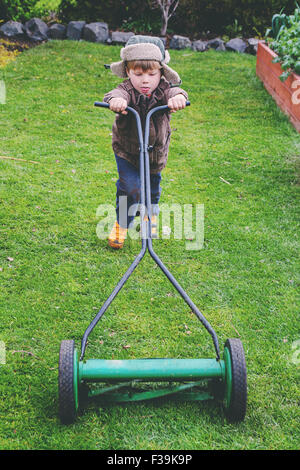 Portrait of a boy mowing lawn Stock Photo