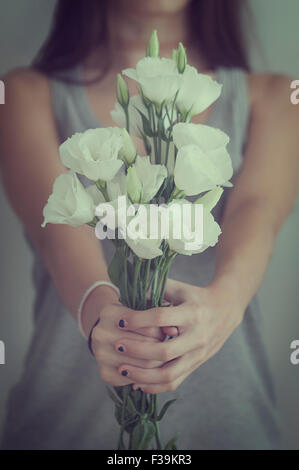Mid section of a teenage girl holding a bunch of  flower Stock Photo