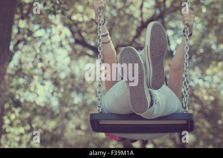 Low angle view of a teenage girl on a swing Stock Photo