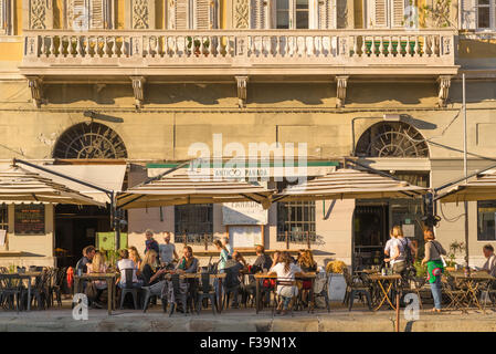 Italy cafe bar summer, visitors to Trieste in Italy enjoy a summer sunset along the city's Canal Grande. Stock Photo