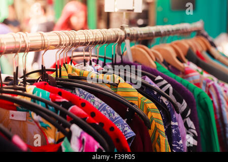 Clothes hanging on a rail at a street market outdoors Stock Photo