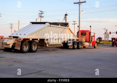 A semi truck parked in a parking lot in rural Oklahoma in evening golden light.. Stock Photo