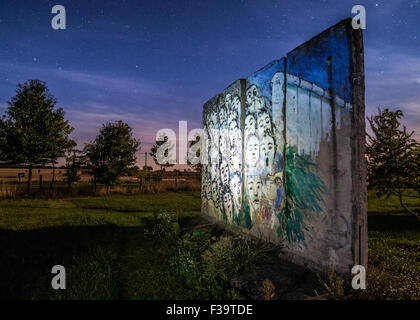 Petersdorf, Germany. 1st Oct, 2015. In the glow of a street light, original concrete sections of the Berlin Wall in the courtyard of a gallery in Petersdorf, Germany, 1 October 2015. To display the painting entitled, 'Es geschah im November( lt: It happened in November' by Iranien Berlin artist Kani Alavi. On 3 October 2015 Germany will have been reunited for 25 years. Photo: Patrick Pleul/dpa/Alamy Live News Stock Photo
