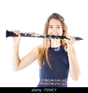 young brunette woman bites clarinet in studio against white background Stock Photo