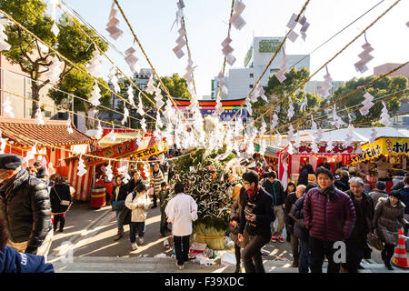 Japan New year. Crowd moving through main gate to visit Ikuta Shrine at Kobe, with foreground Kadomatsue, new year traditional decoration, gate pine. Stock Photo