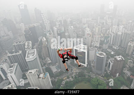 Kl, Kuala Lumpur, Malaysia. 2nd Oct, 2015. Base jumpers leaps from the 300-metre (984 ft.) high .They are piictured against the skyline that shrouded by a thick haze during the Kuala Lumpur Tower International Jump in Kuala Lumpur, Malaysia, 02 October 2015. More than 100 Base jumpers participate in this extreme sport event, which enters its 15th year. The haze hovering over Malaysia is caused by the ongoing plantation and forest fires in the nearby Indonesian provinces of Sumatra and Kalimantan. Credit:  Mohd Hafiz/ZUMA Wire/Alamy Live News Stock Photo