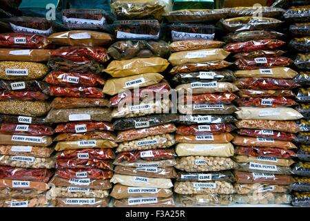 stacks of bags of dried chillies and spices piled up in a street market Stock Photo