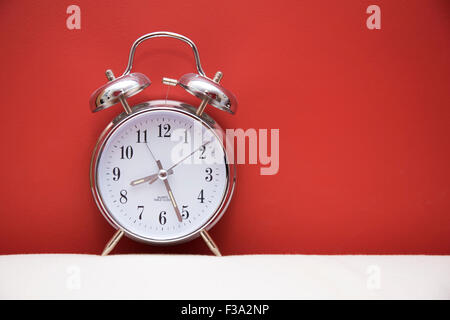 Alarm clock against red and white background Stock Photo