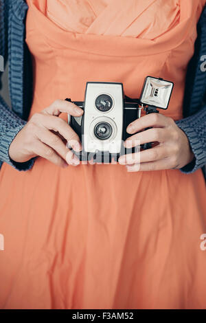Vintage young woman holding an old camera Stock Photo