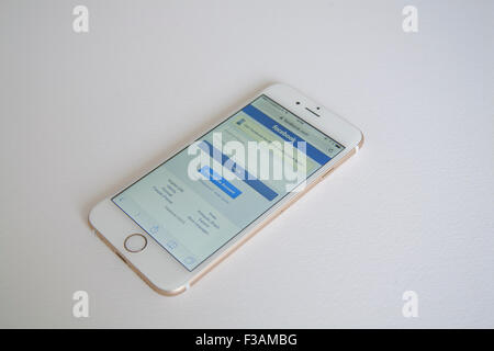 Gold and white Apple iPhone 6 with Facebook log in page against a white background Stock Photo