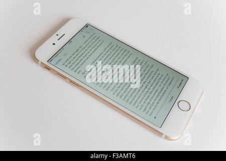 Gold and white Apple iPhone 6 with an ebook on screen against a white background Stock Photo