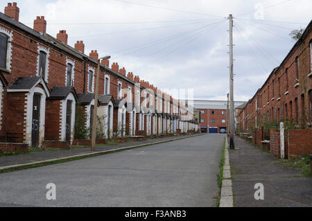 Boarded up houses on a street in west Belfast Stock Photo