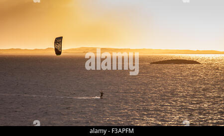 Sunset on North Uist in the Western Isles of Scotland UK with a lone kite surfer making the most of the day Stock Photo