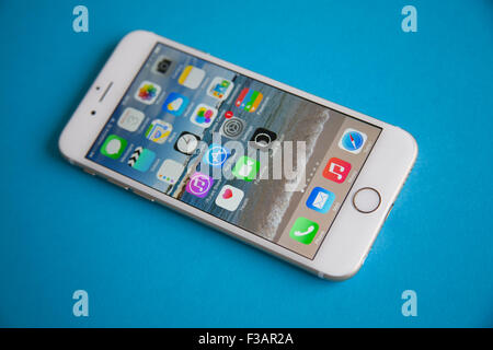 Gold and white Apple iPhone 6 against a blue background Stock Photo