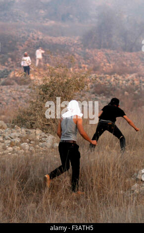 Nablus, West Bank, Palestinian Territory. 3rd Oct, 2015. Palestinian protesters hurl stones towards Israeli settlers during clashes in the West Bank village of Burin on October 3, 2015. Sporadic clashes erupted between Palestinians and a dozen settlers from the settlement of Yitzhar, which is known as a bastion of extremists, when the settlers threw stones at Palestinians who responded in the same wa © Nedal Eshtayah/APA Images/ZUMA Wire/Alamy Live News Stock Photo