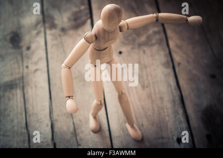 Wooden figurine standing on an old wooden table.