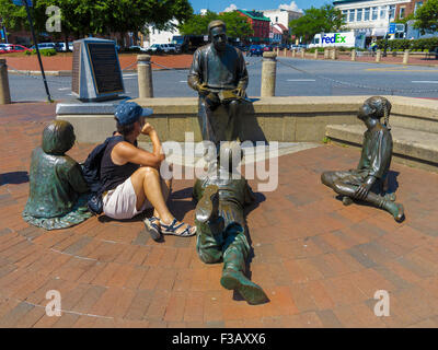 Female sitting alongside the  Alex Haley Kunta-kinte Memorial at City Dock, Annapolis, Maryland, USA Stock Photo