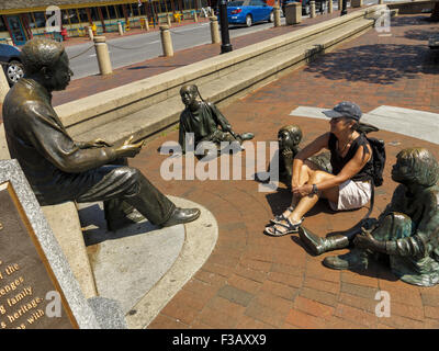 Female sitting alongside the Alex Haley Kunta-kinte Memorial at City Dock, Annapolis, Maryland, USA Stock Photo