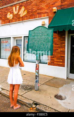 Young teenage girl reads the historic plaque outside of Sun Studio's in downtown Memphis Tennessee Stock Photo