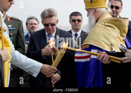 Lemnos island, Greece. 3rd October, 2015. Lighting candles during officiation service by his Grace Archbishop Michael of Geneva and Western Europe (ROCOR - Russian Orthodox Church Outside Russia) at the Russo-Kozak memorial, Punta cape, Limnos, Greece. Credit:  BasilT/Alamy Live News Stock Photo