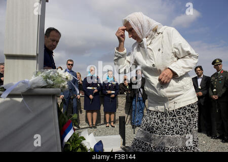 Lemnos island, Greece. 3rd October, 2015. A descendant of the fallen prays in front of the marble cross slab on the Russian-Cossack graveyard's memorial site. Punta hill, Pedino village, Lemnos island, Greece. Credit:  BasilT/Alamy Live News Stock Photo