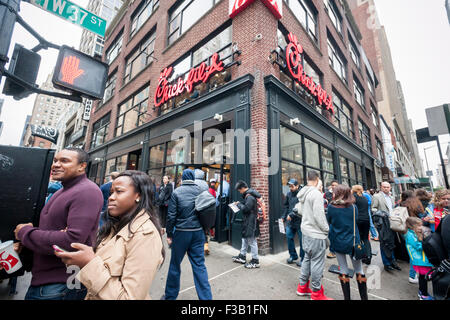 New York, USA. 3rd October, 2015. Customers leave the new Chick-Fil-A fast food restaurant in New York with their purchases on its grand opening, Saturday, October 3, 2015. The 5000 square foot restaurant is the largest in the Atlanta-based company's chain and is located in Midtown Manhattan. The chain has a cult-like popularity with foodies extolling the virtues of their fried chicken sandwiches. Credit:  Richard Levine/Alamy Live News Stock Photo