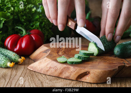 Cutting vegetables on a wooden board, close up view Stock Photo