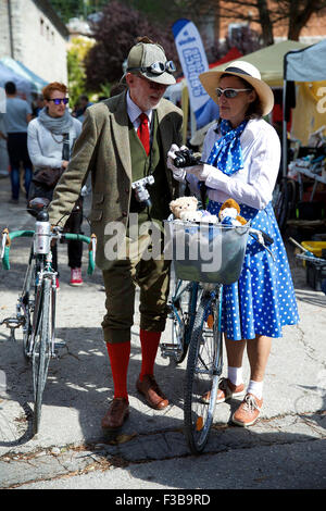 Tuscany, Italy. 3rd Oct, 2015. A couple in vintage clothes visits the ' Eroica (heroic)' vintage bike market in Gaiole in Chianti of Tuscany, Italy, on Oct. 3, 2015. A vintage bike market was held in Gaiole in Chianti from October 2 to October 4, as a part of the 'Eroica (heroic)' cycling race for old bikes, which was founded in 1997, and takes place every October in Gaiole in Chianti. More than 5,500 participants from all over the world were attracted in this non professional event for classic bikes this year. © Jin Yu/Xinhua/Alamy Live News Stock Photo