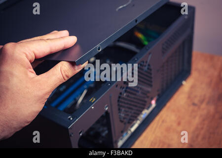 A hand is opening up a computer case Stock Photo